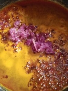 picture of onions and red oil in a pot