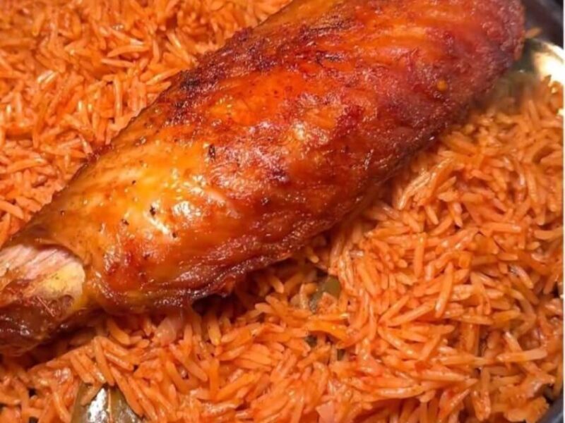 image of nigerian smokey party jollof rice in a plate served with a fried turkey by the side- for how to make nigerian smokey party jollof rice at home.