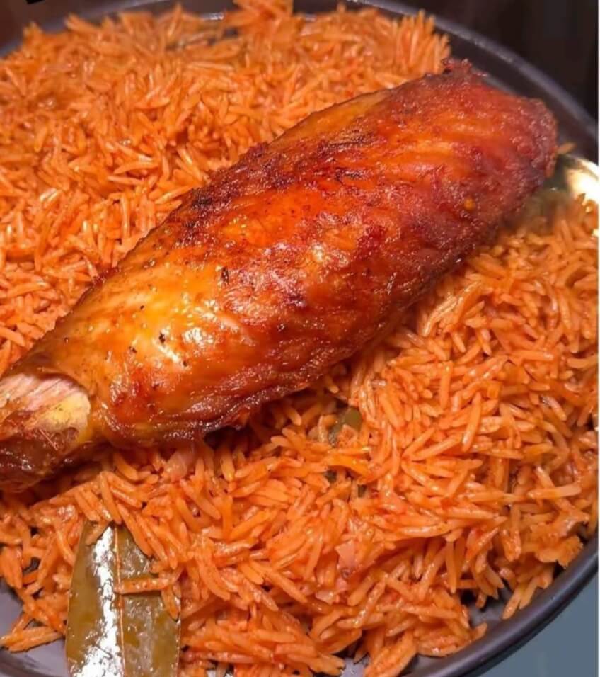 image of nigerian smokey party jollof rice in a plate served with a fried turkey by the side- for how to make nigerian smokey party jollof rice at home.