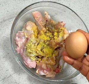 picture of cracked egg into marinated chicken for sweet chicken combo recipe